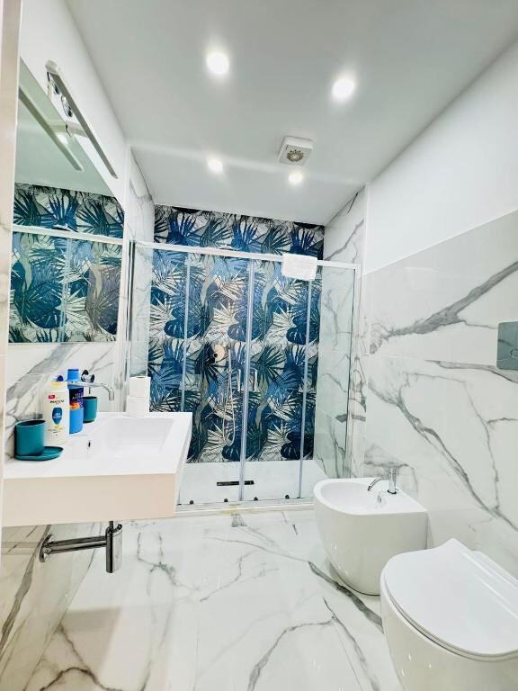 Bagno privato con doccia e rivestimenti in marmo